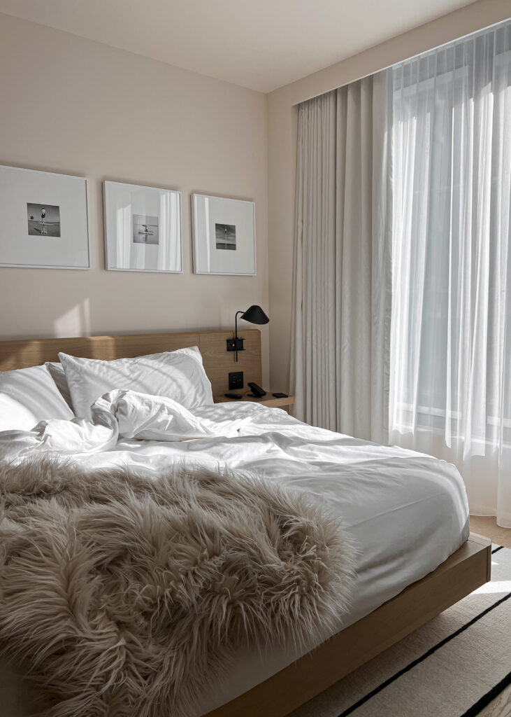 white sheets, furry throw on a bed